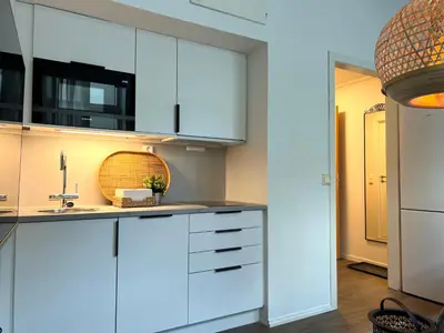 a kitchen with white cabinets and a sink at Vaskerelven 4 in Bergen