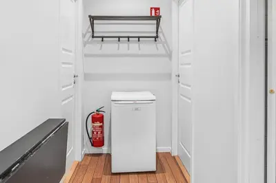 a small refrigerator in a kitchen with a fire extinguisher at Seaside Apt. Catch Crabs from Your Bedroom Window! in Bergen