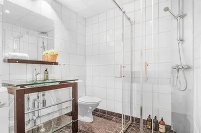 a white bathroom with a shower and a toilet at Seaside Apt. Catch Crabs from Your Bedroom Window! in Bergen