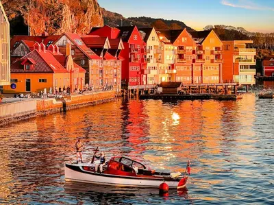 a boat in the water in front of a city at Ocean-view Haven: Take a swim from your window! in Bergen