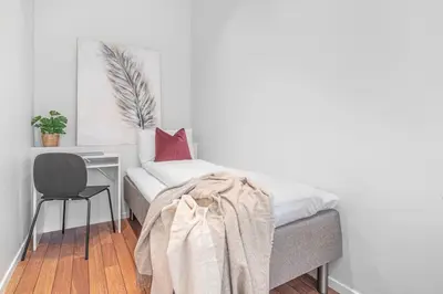 a bed with a desk and a chair in a room at Ocean-view Haven: Take a swim from your window! in Bergen