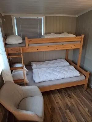 a room with two bunk beds and a chair at Bjørgebu Camping AS in Mysusæter