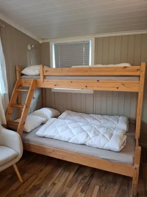 a bedroom with two bunk beds and a chair at Bjørgebu Camping AS in Mysusæter