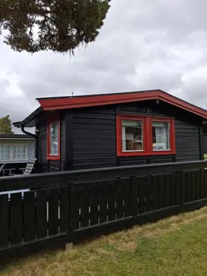 a black house with a red roof at Bjørgebu Camping AS in Mysusæter