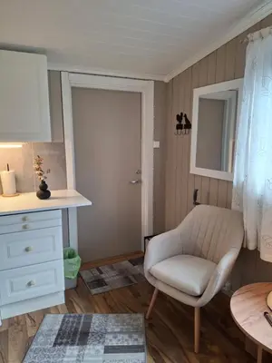a living room with a chair and a table at Bjørgebu Camping AS in Mysusæter