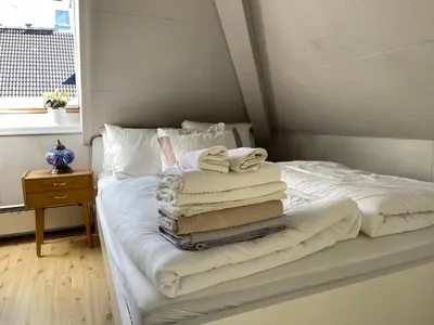 a pile of towels are stacked on a bed at City View & Central Location in Trondheim