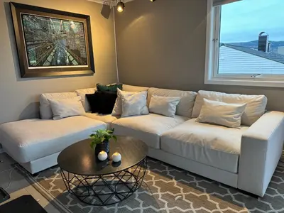 a living room with a white couch and a table at Spacious house near city centre - WSC 2025! in Trondheim