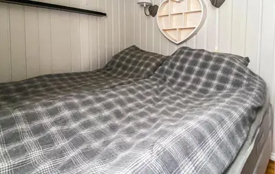 a bed with a checkered blanket in a room at Nice Home In Gol With Kitchen in Golsfjellet