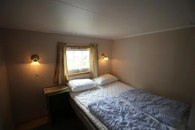 a small bedroom with a bed with a window at Gjerdset Turistsenter in Isfjorden