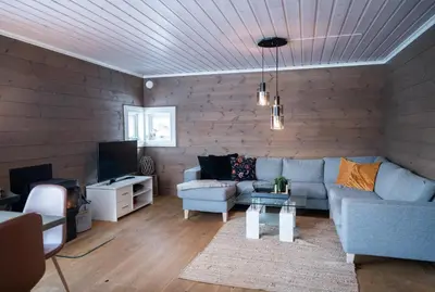 a living room with a couch and a tv at Stranda Fjellgrend - with jacuzzi & 3 bedrooms in Stranda