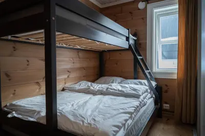 a bedroom with a bunk bed in a log cabin at Stranda Fjellgrend - with jacuzzi & 3 bedrooms in Stranda