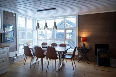 a dining room with a table and chairs and a chandelier at Stranda Fjellgrend - with jacuzzi & 3 bedrooms in Stranda