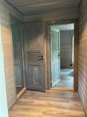 an empty room with two doors and wooden floors at Kvammen in Sæbø