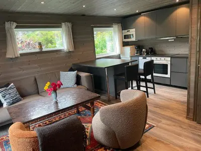 a kitchen and living room with a table and chairs at Kvammen in Sæbø