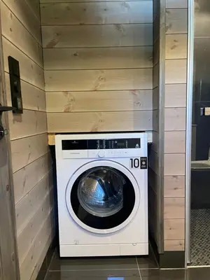 a washer and dryer in a room with wooden walls at Kvammen in Sæbø