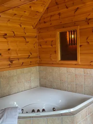 a bath tub in a room with a wooden ceiling at Kvammen in Sæbø