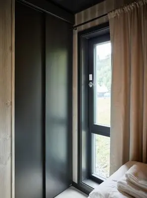 a bedroom with a window and a bed in front of it at Koie Deluxe II in Stranda