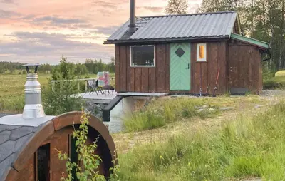 a small house in a field next to a bridge at Cozy Home In Gol With Sauna in Golsfjellet