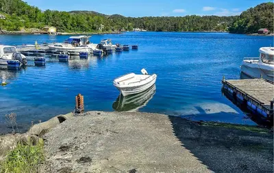 a boat is docked at a dock on a lake at Cozy Apartment In Sveio With Kitchen in Sveio