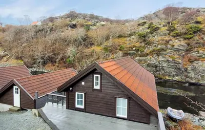 a house with an orange roof on a deck at 2 Bedroom Cozy Home In Finnås in Grutle