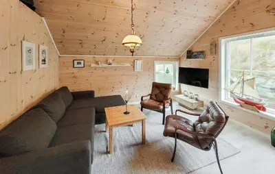 a living room with a couch and chairs and a tv at 2 Bedroom Cozy Home In Finnås in Grutle