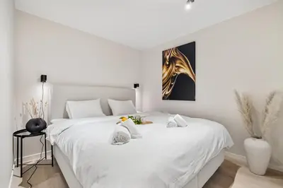 a bedroom with a white bed with two stuffed animals on it at King bed - Renovated 2024 - 2BR Behind Bryggen in Bergen