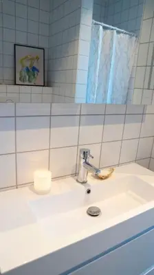 a bathroom with a sink and a mirror at Cozy Nature Retreat, Danish Design w Jacuzzi option in Sogndal