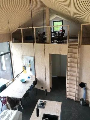 a room with a desk and a table and a ladder at Cozy Nature Retreat, Danish Design w Jacuzzi option in Sogndal