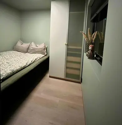 a small bedroom with a bed and a mirror at Sognefjorden View in Leikanger