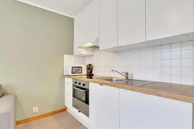 a white kitchen with a sink and a microwave at Easy Living in Bergen