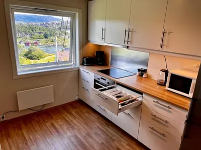 a kitchen with a window and a sink and a stove at Fjord-View Retreat with Free Parking and Fast Internet in Nese