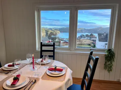 a table with chairs and a table with a window at Fjord-View Retreat with Free Parking and Fast Internet in Nese