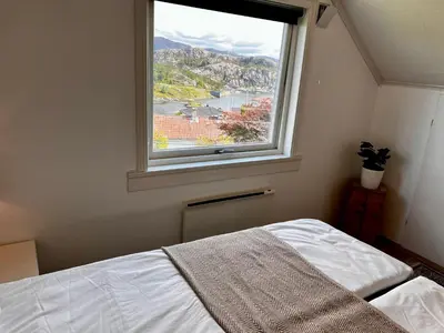a bedroom with a bed and a window with a view at Fjord-View Retreat with Free Parking and Fast Internet in Nese