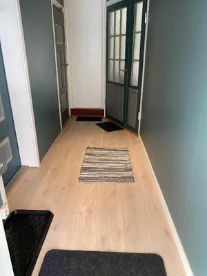 a hallway with a door and a rug on the floor at Heinåli apartment in Isfjorden