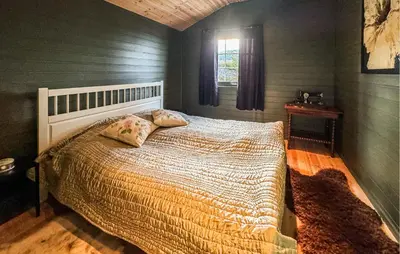 a bedroom with a bed with a comforter and a window at Awesome Home In Fevåg With Wifi in Fevåg
