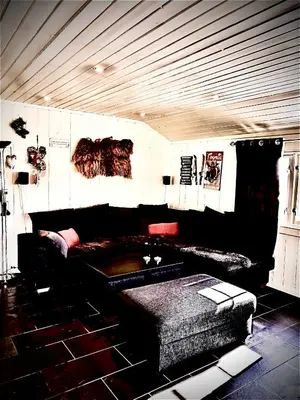 a living room with a black couch and a chair at Hytta for 8 personer skiut/inn in Trysil