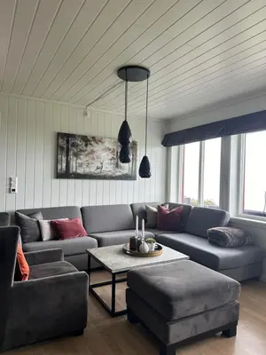a living room with a couch and a table at Apartment with beautiful panoramic view in Skulestadmo