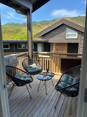 a porch with chairs and a table on a deck at Sentral leilighet på Geilo in Geilo