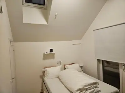 a small room with a bed with white sheets at Ny og moderne leilighet, midt i byen1 in Trondheim