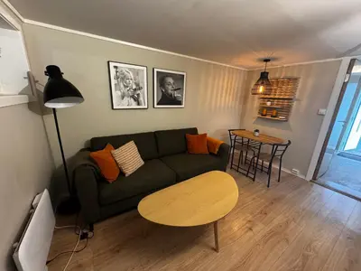a living room with a green couch and a table at Apartment close to Aalesund center in Ålesund