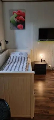 a bed in a room with a tv on a wall at Hus i flott natur in Skjåk