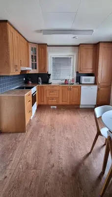 a large kitchen with wooden cabinets and a table at Hus i flott natur in Skjåk