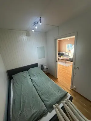 a bedroom with a bed and a door to a room at Modern and central Apartment - Solsiden Trondheim - Up to 6 people in Trondheim