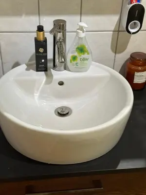 a white sink with a bottle of soap on it at Leilighet med nydelig utsikt over Bergen in Bergen