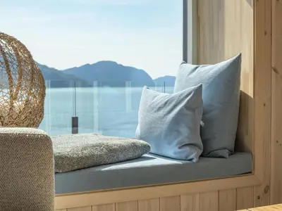 a window seat with pillows in front of a window at Holiday Home Hildebu by Interhome in Sørbø