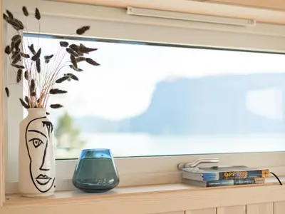 a window sill with a vase and a glass at Holiday Home Hildebu by Interhome in Sørbø