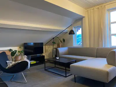 a living room with a couch and a table at Bed and Brunsj, Sand in Sand