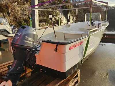 a boat with a machine parked on a dock at Svært nydelig fritidshytte in Forland
