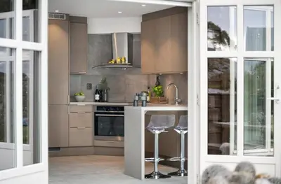 a kitchen with a counter and stools in it at Svært nydelig fritidshytte in Forland