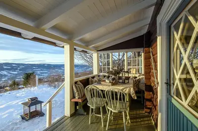 a screened in porch with a table and chairs on it at Koselig hytte 10 minutter fra Lillehammer sentrum in Lillehammer